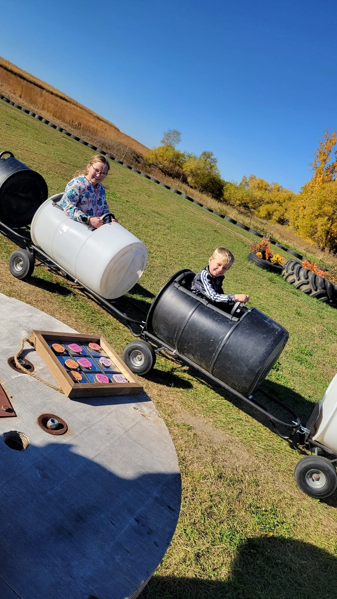 A kid riding the barrel train at Willow Meadows Farm